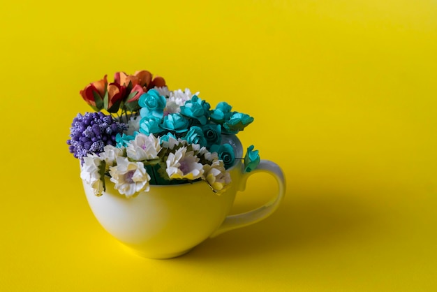 Una tazza bianca dal concetto creativo con bevanda calda con un grande bouquet di fiori all'interno