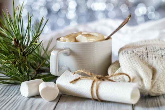 Una tazza di cacao e marshmallow nella tavola di Natale di Capodanno su uno sfondo lucido