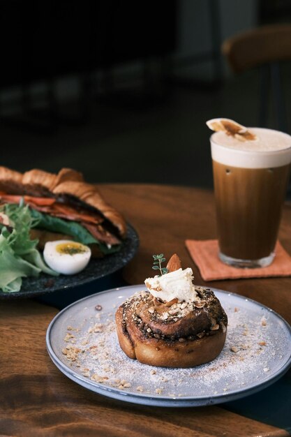 una tazza di caffè accanto a un piatto di cibo e un piotto di cibo