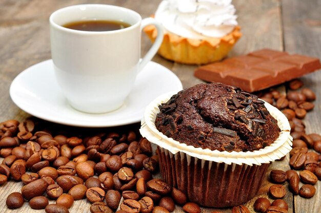 Una tazza di caffè accanto a una tazza di caffè e un muffin