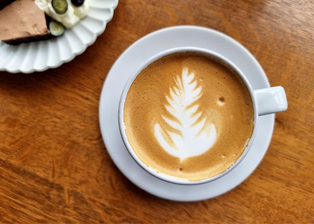 Una tazza di caffè caldo di arte del latte su fondo di legno