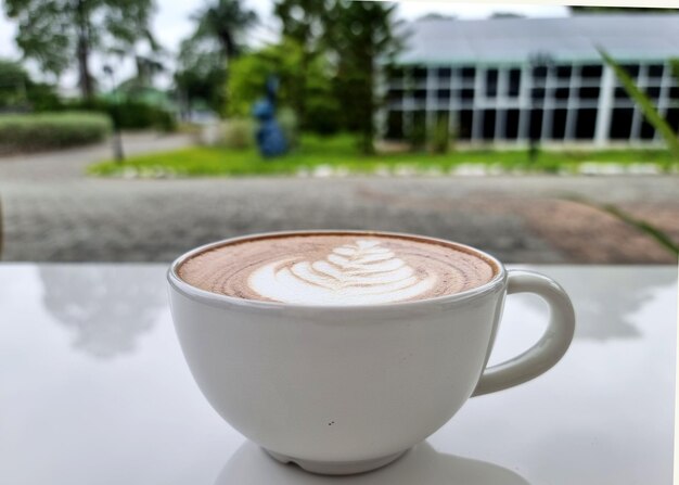 Una tazza di caffè caldo latte art su sfondo sfocato