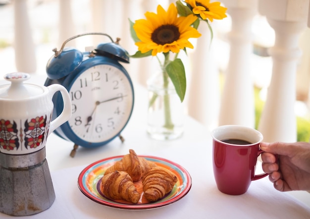 Una tazza di caffè con dei fiori in vaso sul tavolo