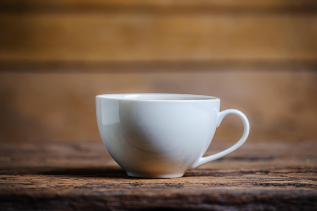 Una tazza di caffè con il chicco di caffè su fondo di legno