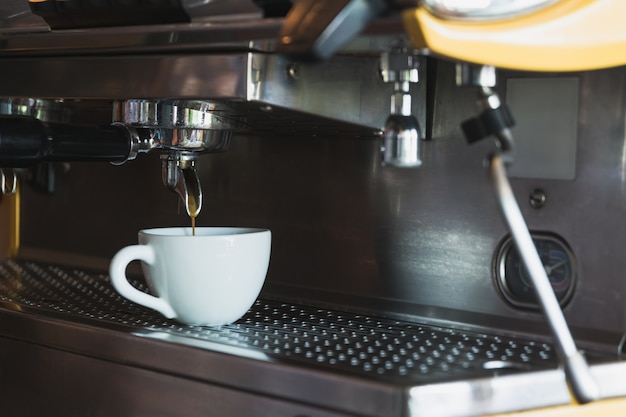 Una tazza di caffè con macchina per il caffè in caffetteria.