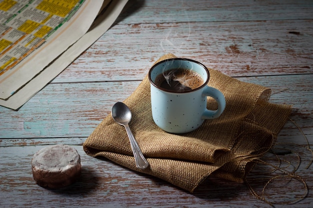 Una tazza di caffè con un biscotto fatto in casa e un giornale su un tavolo di legno Tempo di rilassarsi Fare una pausa