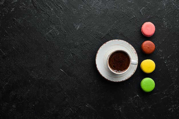 Una tazza di caffè con una torta di amaretti su uno sfondo di pietra nera Vista dall'alto Spazio libero per il testo