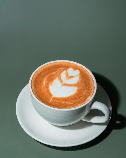 Una tazza di caffè e chicchi di caffè su sfondo verde Vista dall'alto Copia spazio
