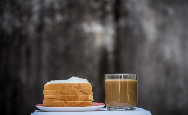 Una tazza di caffè e pane con uno sfondo grigio