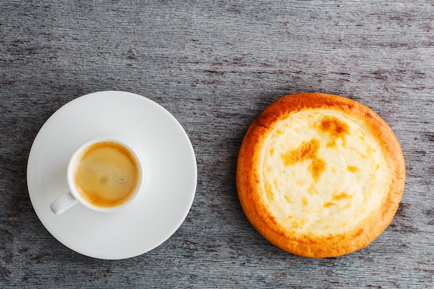 Una tazza di caffè espresso su un piatto e un panino