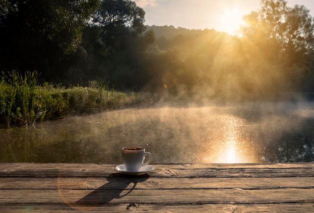 Una tazza di caffè fresco profumato in natura Foto a fuoco morbido del caffè nella calda luce del mattino