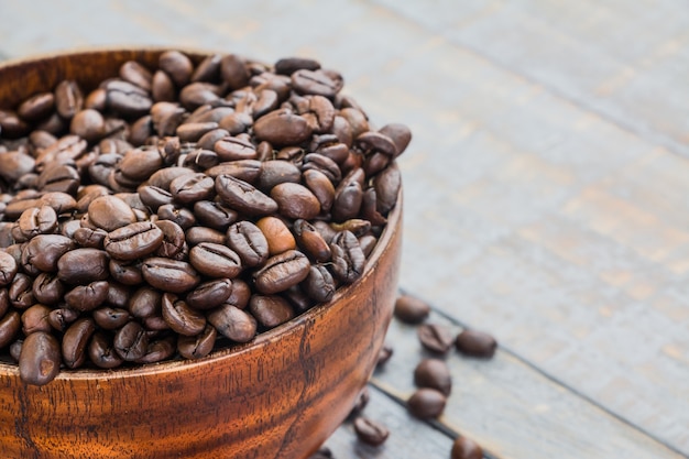 Una tazza di caffè in grani su sfondo di legno