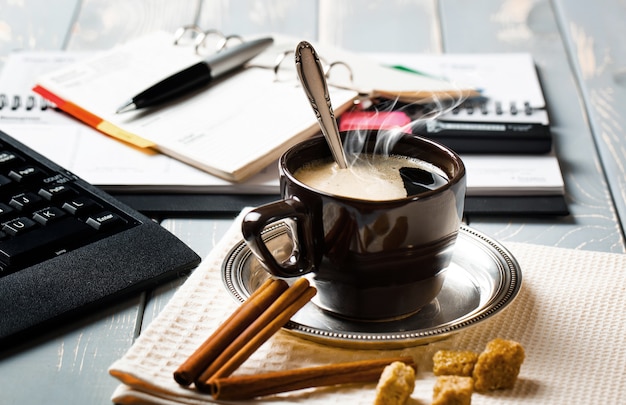 Una tazza di caffè in ufficio con oggetti per fare affari.