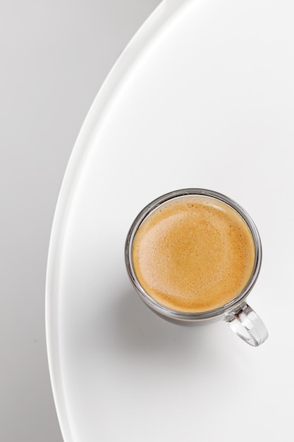 Una tazza di caffè in vetro con caffè espresso al mattino sul tavolo bianco Aroma ristretto Glass Close up top