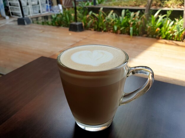 Una tazza di caffè latte art caldo su un tavolo di legno