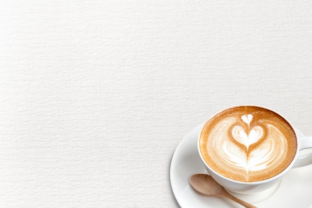 Una tazza di caffè latte con un cucchiaio su carta blackground