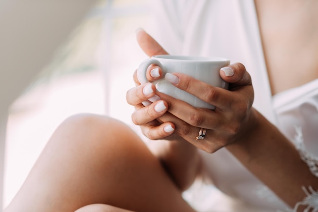 Una tazza di caffè mattutino nelle mani delle donne 3771