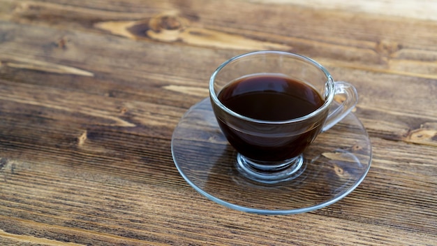 Una tazza di caffè nero caldo su un tavolo di legno