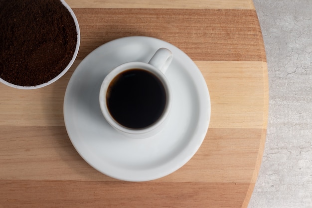 Una tazza di caffè nero e caffè macinato.