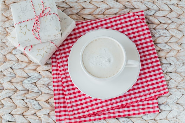 Una tazza di caffè o cappuccino e due confezioni regalo su sfondo bianco