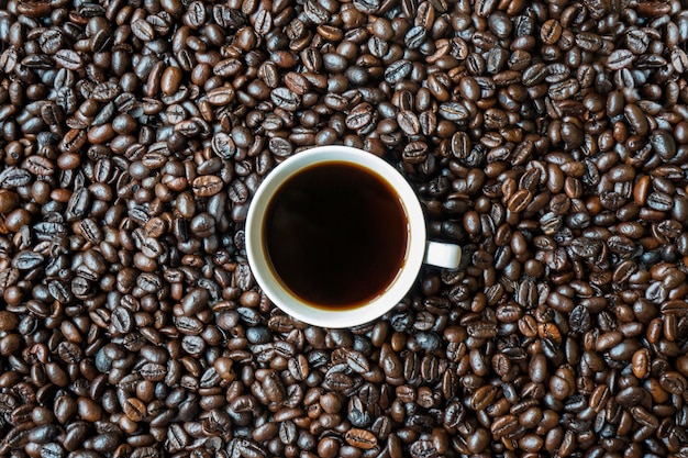 Una tazza di caffè su un mucchio di chicchi di caffè