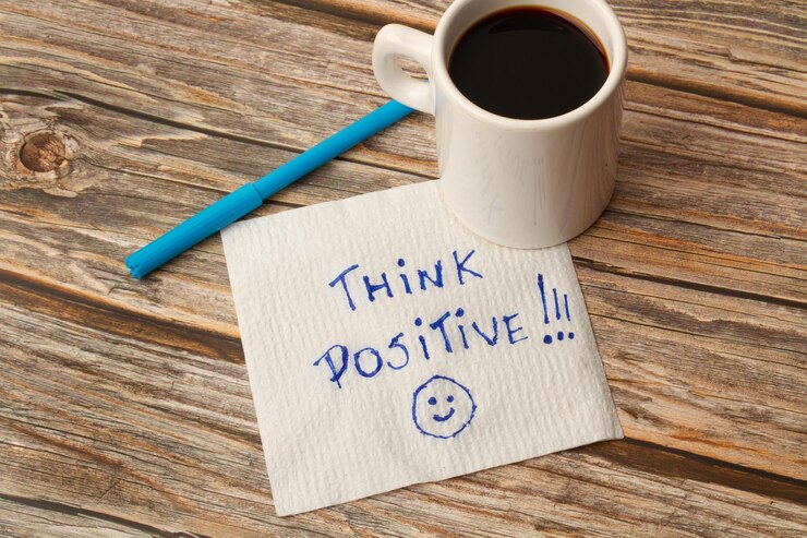 Foto una tazza di caffè su una carta con una breve frase positiva e un marcatore su un tavolo di legno