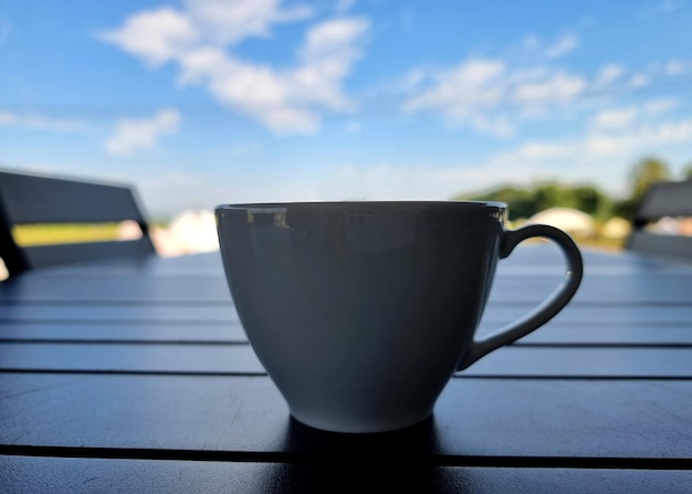 Una tazza di caffè su una nuvola sfocata sullo sfondo del cielo blu
