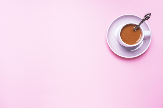 Una tazza di caffè su uno sfondo rosa con spazio di copia. Vista dall'alto. minimalismo.