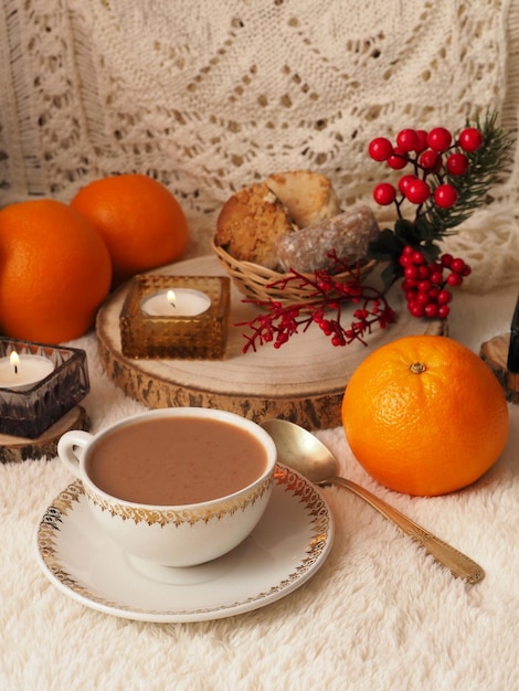 Una tazza di cioccolata calda, biscotti, arance, candele, decorazioni natalizie