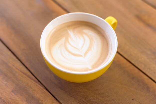 Una tazza di latte art sul tavolo di legno