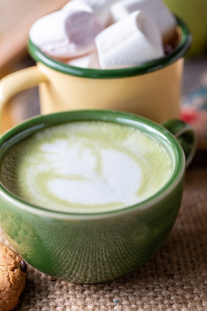 Una tazza di latte caldo matcha sul pavimento di legno