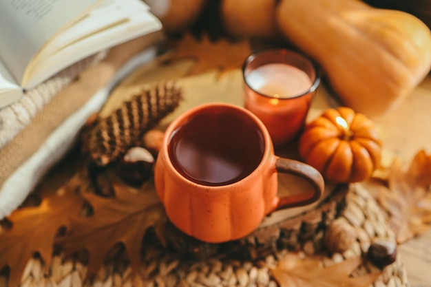 Una tazza di tè a forma di zucca e decorazioni autunnali sulla foto estetica del davanzale