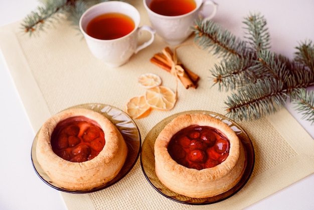 Una tazza di tè caldo e torta. Biglietto natalizio. Il ramo dell&#39;albero è abete rosso.