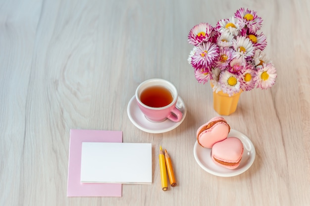 Una tazza di tè con macarons a forma di cuore