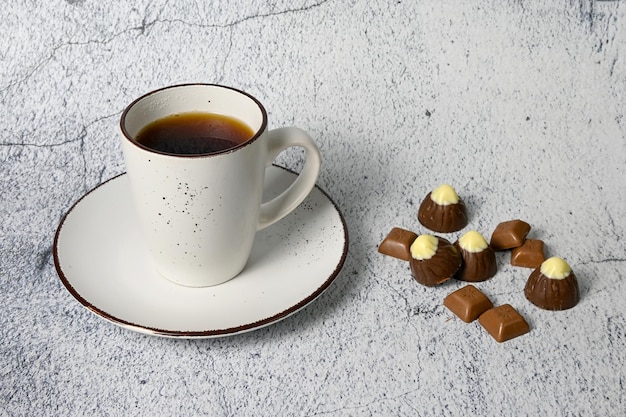 Una tazza di tè e cioccolatini sul tavolo