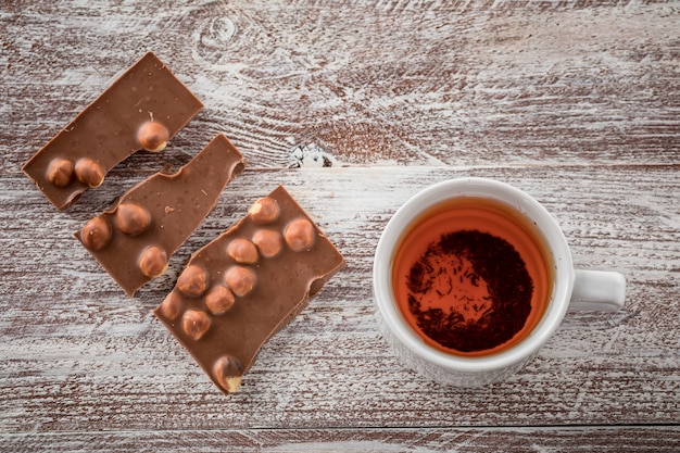 Una tazza di tè è cioccolato nero sul legno