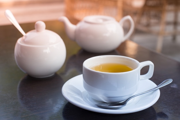 Una tazza di tè in primo piano è sul tavolo del caffè.