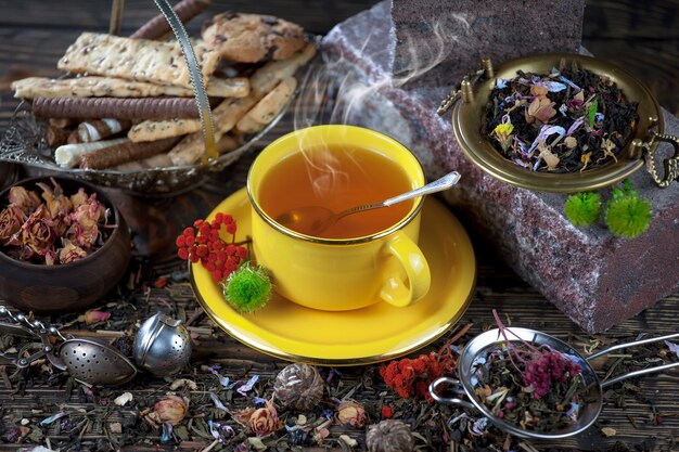 Una tazza di tè si trova su un tavolo accanto a una tazza di tè.