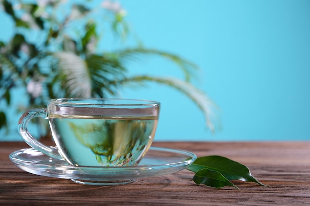 Una tazza di tè verde sul tavolo su uno sfondo verde