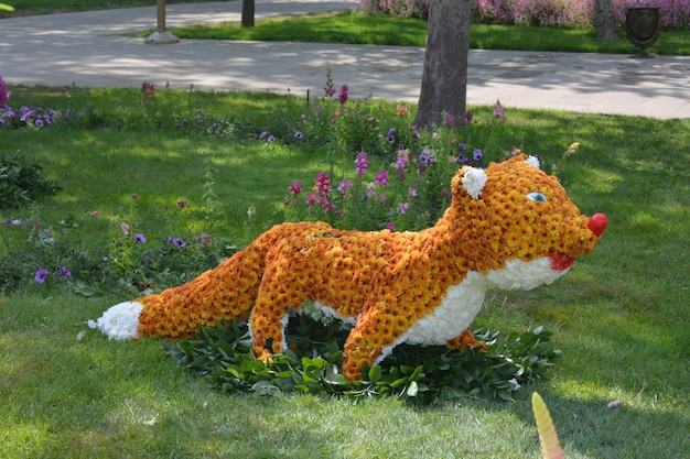 Una tigre fatta di fiori è esposta in un giardino.