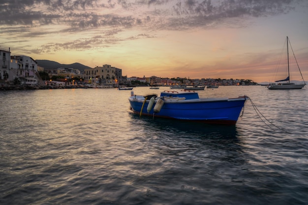 Una tipica barca da pesca ormeggiata al porto di Ischia Ponte al tramonto, Ischia, Italia