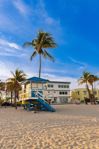 Una torre del bagnino si trova su una spiaggia di fronte alle palme.