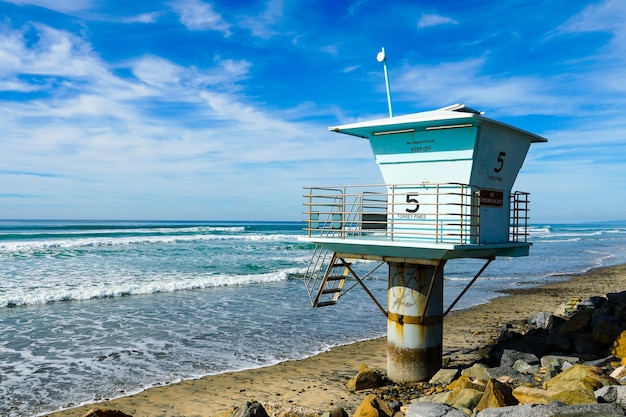 Una torre del bagnino su una spiaggia con sopra il numero 5.