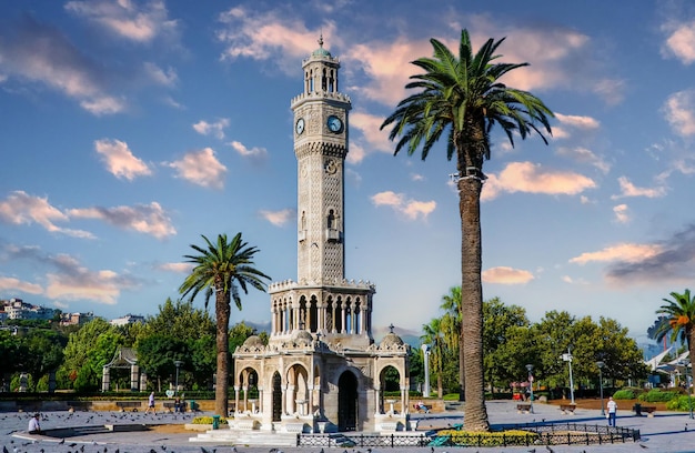 una torre dell'orologio con un orologio e palme sullo sfondo