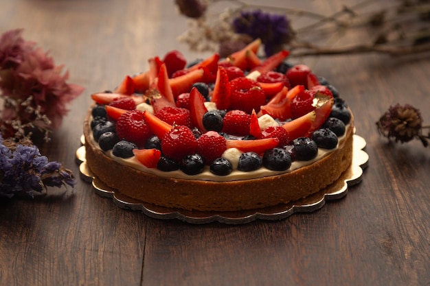 una torta con bacche e mirtilli su un piatto d'oro