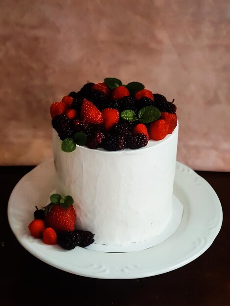 Una torta con frutti di bosco sopra è su un piatto.