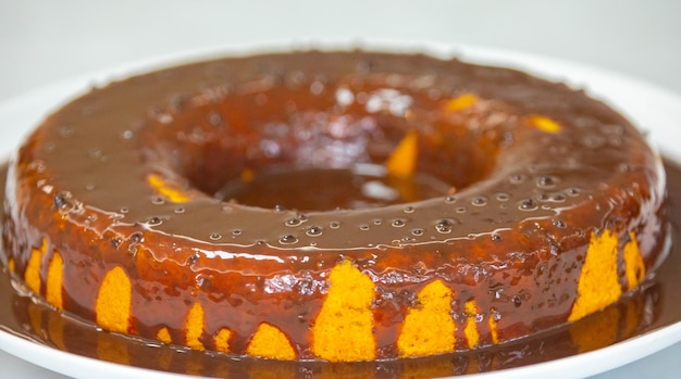 una torta di cioccolato con glassa arancione e gialla e spruzzate di arancione su di essa