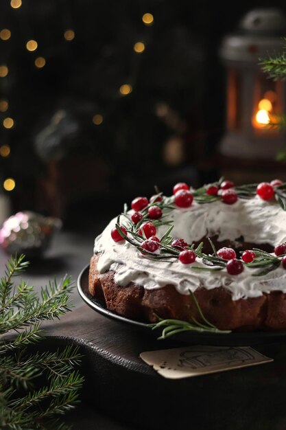 Una torta di Natale con una candela sullo sfondo