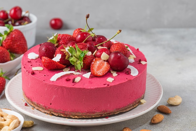 Una torta rosa con sopra una fragola