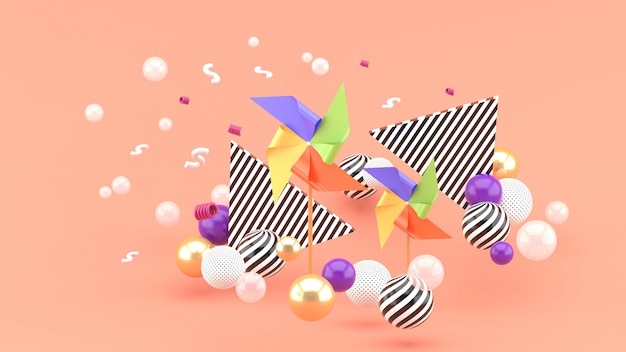 Una turbina di carta multicolore in mezzo a palline colorate sul rosa. Rendering 3d.